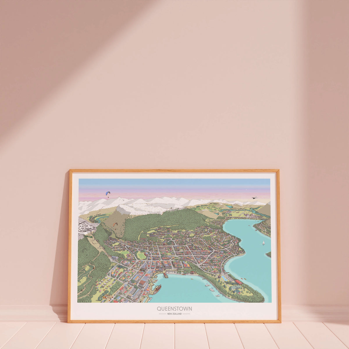 Hand-drawn map of Queenstown, New Zealand, featuring the town centre, waterfront, gondola and luge tracks, surrounding buildings, and Lake Wakatipu. Created in a detailed illustration style with digital colouring over pencil and pen. Displayed with wood frame.