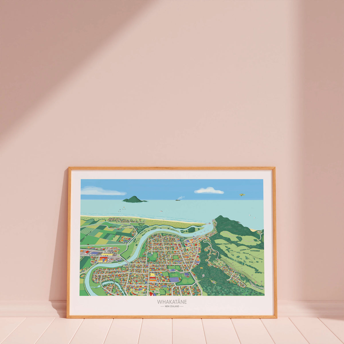 A hand-drawn map art print of Whakatāne, New Zealand. The illustration uses a playful perspective to highlight the Whakatāne River, Mokoroa Reserve, and Moutohora Island. Wood frame displayed